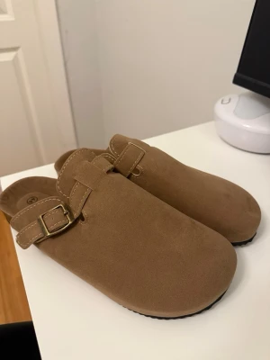 Birkenstock-liknande sandaler - Mocka Birkenstock-liknande sandaler, helt nya. Dam storlek 44, passar mer som 43. Funkar även för herr storlek 41-42.
