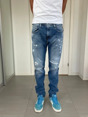 Replay Anbass Jeans  - Säljer nu dessa Replay Anbass Jeans med snygga slitningar i populär design, W33 o L34 med mått ca 41,5-42 o 110 cm. moddelen är 183 och väger 68 kg. Skriv för fler bilder/frågor🙌🏼