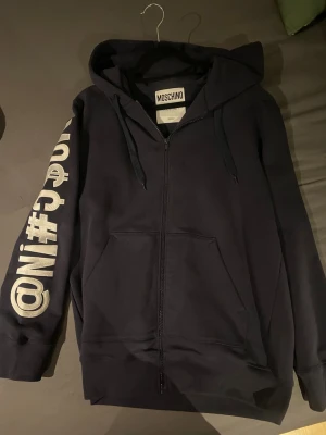 Moschino zip up hoodie - Mörkblå/marinblå Moschino zip up hoodie , nypris cirka 5 lax, priset är ej hugget i sten vill gärna bli av me den så skriv o lämna ett bud ba