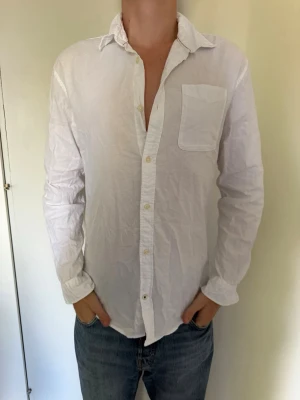 Vit skjorta från Jack & Jones - Klassisk vit skjorta från Jack & Jones med lång ärm, bröstficka och knappar framtill. Skjortan har en avslappnad passform. Fint skick. Hör av dig om du har några frågor eller vill ha fler bilder. Pris kan diskuteras! 