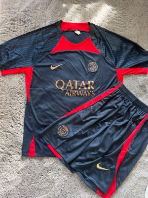 PSG träningsett  - Ett PSG träningsett med T-shirt + shorts med fickor, storlek L
