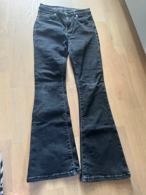 Svarta low flare jeans - Säljer ett par svarta jeans med low waist och flare-ben. De är ifrån Bikbok och är i st S och längd 31. De är lite slitna i skrevet men annars är de i bra skick