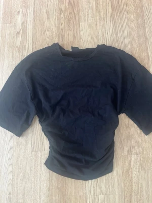 Svart t-shirt från Gina Tricot - En basic svart t-shirt från Gina Tricot i storlek XS. T-shirten har rund halsringning och korta ärmar. Perfekt att matcha med jeans eller kjol för en enkel och clean look.