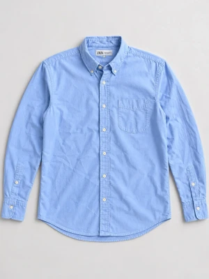 Ljusblå skjorta med knappar - Klassisk ljusblå skjorta med button-down krage och bröstficka. Skjortan har långa ärmar och vita knappar framtill samt vid ärmsluten. Perfekt för en clean och stilren look.