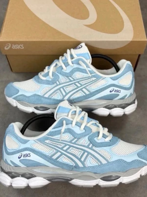 Asics GEL-NYC blå och vita sneakers - Excellent condition ASICS sneakers in a beautiful light blue and white colorway. Comfortable, stylish, and perfect for everyday wear. ✅ Original box included ✅Original receipt included ✅ Clean and well maintained ✅Ready to ship These sneakers combine comfort and sporty style, making them ideal for casual outfits, walking, or daily use. Feel free to contact me if you have any questions or would Like more photos.