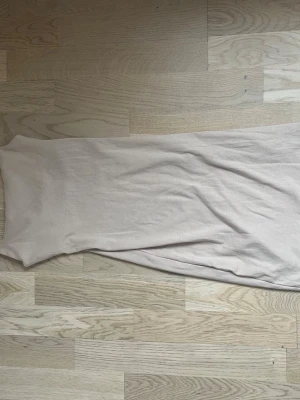 Beige långklänning från Zara - Säljer en enkel och stilren beige långklänning från Zara. Klänningen har en rak passform och är ärmlös, vilket gör den perfekt för varma dagar. Materialet känns mjukt och lätt mot huden.