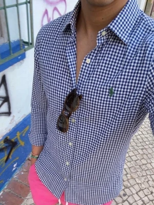 Blårutig skjorta från Polo Ralph Lauren - Säljer en slim fit skjorta från Polo Ralph Lauren i blåvitt rutigt mönster. Skjortan har klassisk krage, knäppning framtill och den ikoniska gröna loggan broderad på bröstet. Perfekt för en clean och stilren look.