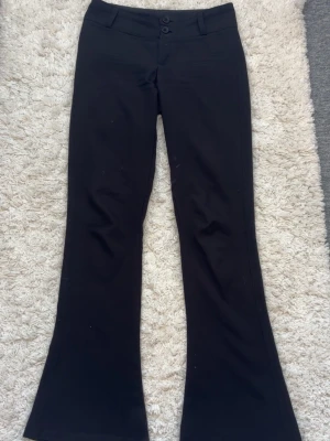 Gina Tricot svarta utsvängda kostymbyxor – strl S🤍 - Säljer ett par svarta utsvängda kostymbyxor från Gina Tricot 🖤  • Storlek: S • Modell: Mid waist / utsvängda • Använda några gånger • Har fickor med knappar framtill • Lite noppiga på vissa ställen, men nopporna går enkelt att ta bort med t.ex. en noppmaskin  I övrigt i fint skick och inga hål eller större skador.