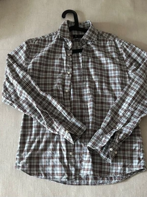 Rutig skjorta från Riley - Klassisk rutig skjorta från Riley i vitt, grått och brunt. Skjortan har lång ärm, knappar framtill och en mjuk krage. Perfekt till jeans eller chinos för en avslappnad men snygg look.