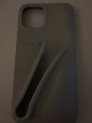 Grått mobilskal från rhode - Snyggt grått mobilskal från rhode med unik upphöjd design på baksidan. Tillverkat i mjukt silikonmaterial som ger bra grepp och skydd. Passar perfekt för dig som vill ha ett stilrent och modernt skal till din mobil.