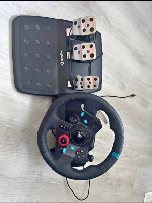 Logitech ratt och pedaler till PS4/PS5 - Säljer en Logitech ratt och pedalset för PlayStation. Ratten är svart med blå detaljer och har en greppvänlig yta i konstläder. Pedalerna är i metall och plast, med tre pedaler för realistisk racingkänsla. Perfekt för dig som vill ta din racingupplevelse till nästa nivå.
