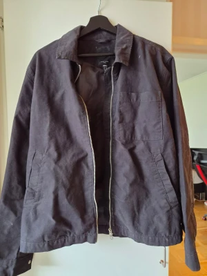 Svart jacka från New Look - Säljer en svart jacka från New Look med dragkedja framtill, klassisk krage och tre fickor. Jackan är tillverkad i ett mjukt tyg och har en enkel, stilren design som passar till det mesta. Perfekt för dig som gillar minimalistisk stil.