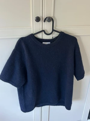 Mörkblå stickad t-shirt  - Mörkblå stickad t-shirt från Gina Tricot som knappt är använd! Passar mig som har xs i vanliga fall