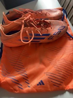  Fotbollskor adidas f50 - Säljer ett par grymma orangea Adidas F50 som är använda  6 gånger jag säljer de då ja inte kan ha de för de är för små på mig påse ingår även adidas box putsa kan diskuteras.