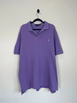 Polo Ralph Lauren Pikétröja Lila Classic Fit Bomull Stl XL - • Storlek: XL • Färg: Lila / lavendel • Passform: Classic Fit  • Krage: 2-knappsstängnin • Material: 100% bomull  Skick: Plagget är i väldigt fint skick. Eventuella anmärkningar anges alltid tydligt i beskrivningen och visas på bilderna.  Nypris: Cirka 1 600 kr.  📦 Skickas snabbt och packas omsorgsfullt. 💬 Hör gärna av dig om du har frågor eller vill se fler bilder. 🤝 Samfrakt erbjuds vid köp av flera plagg – kika gärna in mina andra annonser!