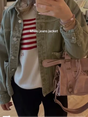 Grön  jeansjacka - Snygg jeansjacka  med klassiska sömmar och stora fickor framtill. Jackan har silverfärgade knappar och avslappnad passform, perfekt att slänga över en hoodie eller t-shirt för en cool look.
