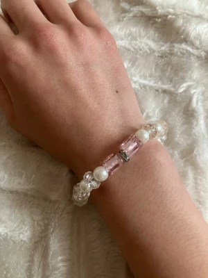 Armband 3 stycken  - Säljer 3 st armband med vita pärlor, klara kristalliknande pärlor och två större ljusrosa pärlor i mitten😊