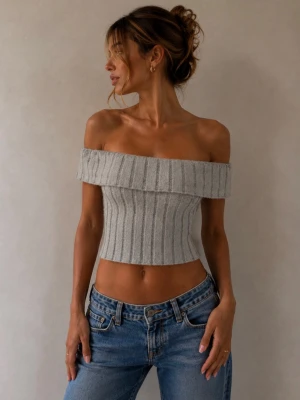 Ljusgrå ribbad offshoulder topp - Trendig ljusgrå croppad topp med ribbad struktur och offshoulder-design. Toppen är ärmlös och har en bred kant upptill som ger en snygg siluett. Perfekt att styla med jeans eller kjol för en cool look.