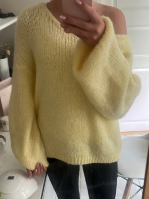Gul oversized stickad tröja - Mysig oversized stickad tröja i ljusgul färg. Tröjan har breda ärmar och en avslappnad passform med rund halsringning. väldigt fin att ha som one shoulder. endast använd en gång.