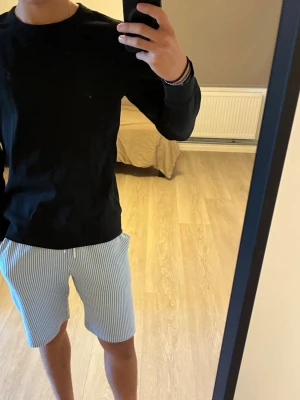 Svart långärmad tröja från Ralph Lauren - Säljes då för liten på mig. Längd är 61 cm passar XS/S. Säljer en svart långärmad tröja från Ralph Lauren med den klassiska blå loggan broderad på bröstet. Tröjan har rund halsringning och är tillverkad i mjukt bomullsmaterial. Perfekt basplagg för en clean och stilren look.