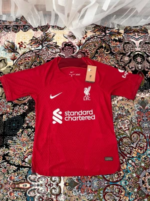 Liverpool matchtröja Nike röd - 🇩🇪 OBS! Jag reser till Tyskland 23 Juli – 30 Juli och kan därför inte skicka paket under denna period.  ✅ Plagget är i nyskick med originallapp och förpackning kvar.  📦 Köper du nu reserverar jag varan åt dig och skickar direkt när jag är tillbaka den 30 Juli. Betalning sker nu, frakt sker efter hemkomst.  💬 Hör av dig om du har frågor – svarar så snart jag kan! 🙏