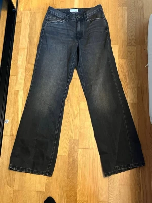 Svarta wide leg jeans - Säljer ett par svarta jeans med wide leg passform och klassisk femficksdesign. Jeansen har hög midja och raka, vida ben. Materialet är denim i bomull och de har en snygg tvättad look. Perfekta för en avslappnad och trendig stil. Storlek 32/34