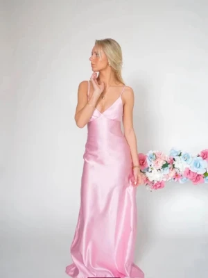 Lång rosa  bal satinklänning med smala band - Elegant långklänning i glansigt rosa satin med smala axelband och v-ringning. 