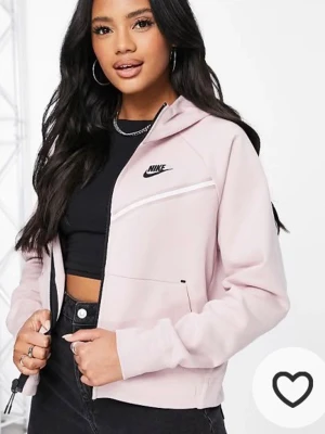 Ljusrosa hoodie från Nike - Säljer en ljusrosa hoodie från Nike med dragkedja framtill och svart Nike-logga på bröstet. Hoodien har huva, långa ärmar och vita detaljer vid bröstet. Perfekt för en sportig och avslappnad stil. Den är formad men släpper fint neråt, perfekt cropped, helt underbar helt enkelt men säljer pga flytt, använd 2 gånger, köpt för 2700kr i USA 