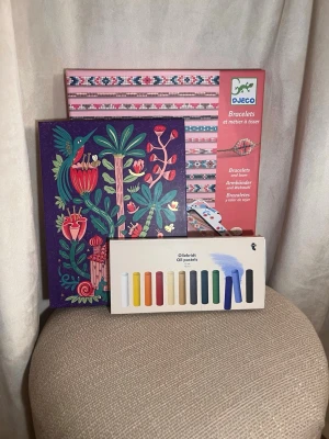  Pysselkit  - Säljer ett kreativt pysselkit som innehåller ett set med färgglada oljepasteller, ett block med brev papper och kuver med tropiskt motiv samt ett armbandskit från Djeco med pärlor och tråd. Perfekt för dig som gillar att skapa och pyssla. Allt är värt ungefär 450-600kr, alla produkter är oanvända och i nytt skick 💗