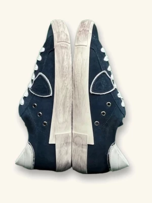 Mörkblå sneakers med vita detaljer - Snygga mörkblå sneakers med vita sulor och vita skosnören. Skorna har metallöljetter och kontrasterande vita detaljer vid häl och tå. Klassisk låg modell som passar till många olika stilar.