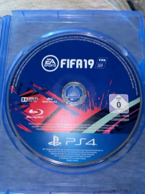 FIFA 19 till PS4 - FIFA 19 till PlayStation 4 på Blu-ray disc. Omslaget är blått och spelet har en färgstark design med röda och svarta penseldrag. Perfekt för dig som gillar fotbollsspel och vill utmana vänner i olika ligor och turneringar.