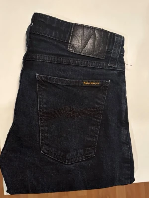 Nudie Jeans - Säljer ett par schyssta Jeans från Nudie Jeans i gott skick och besparat använda! Jeansen är av mörkblå färg med en normal och rak passform. Storlek W29 L30. 