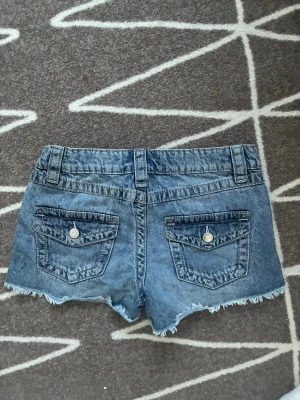 Blå jeansshorts  - Säljer Gina Young-jeansshorts i minimodell med låg midja. Storlek 158, motsvarar XS. Fina fickor. Toppskick! 🤍 #lowwaist #minishorts #jeansshorts #lågmidja #2000tal #y2k #stockholmstil #stockholmstyle 🌟
