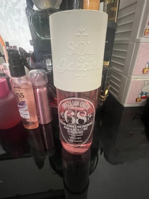 Sol de Janeiro Brazilian Crush 68 - Sol de Janeiro Brazilian Crush Cheirosa 68 är en parfymmist i en genomskinlig rosa plastflaska med vit kork. Doften har inslag av brasiliansk jasmin och pink dragonfruit. Flaskan har en modern och trendig design med tydlig logga och text.