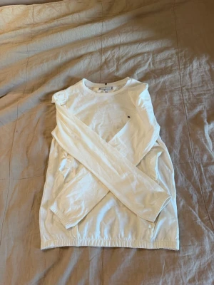 Vit långärmad tröja Tommy Hilfiger - Säljer en stilren vit långärmad tröja från Tommy Hilfiger. Tröjan har rund halsringning, diskret logga på bröstet och är tillverkad i mjukt material. Perfekt till en clean och enkel look. Str 164 men skulle passa xs-s Helt ny aldrig använd! Kontakta innan köp! 