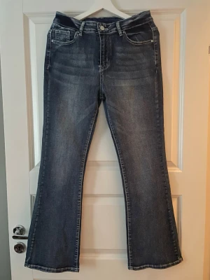 Mörkblå bootcut jeans midrise  - Säljer ett par mörkblå bootcut jeans med midrise midja. Aldrig använda då de inte passade mig!