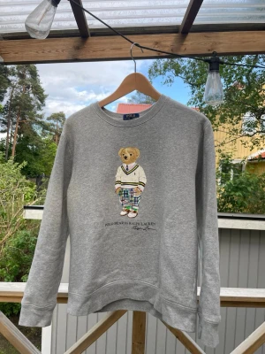 Grå sweatshirt Polo Bear Ralph Lauren - Grå polo bear från Ralph lauren, i väldigt bra skick ! Passar till både tjejer och killar. Säljer för att jag vuxit ur den, hör av er vid funderingar.