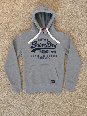 Superdry Hoodie Grå - Superdry Hoodie grå - Storlek: S - Pris: 599kr - Väldigt fint skick och fräsch. - Först till Kvarn!