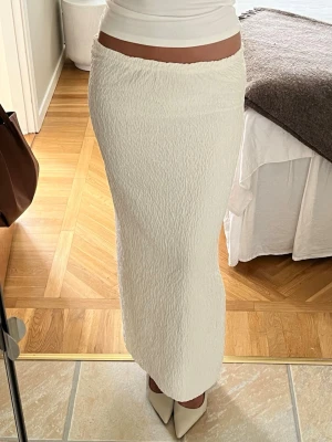 Vit långkjol - Säljer en stilren vit långkjol med strukturerat tyg.❣️