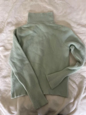 Ljusgrön polotröja från Zara - Mysig ljusgrön stickad polotröja från Zara. Tröjan har bred ribbstickad polokrage, muddar och nederkant. Perfekt för kalla dagar och enkel att matcha med jeans eller kjol. Fin passform, köpt på Vinted. 