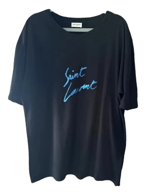 Saint Laurent t-shirt - Svart t-shirt från Saint Laurent med blå logotyp framtill. Klassisk rund halsringning och korta ärmar. Tillverkad i mjuk bomull för en skön och avslappnad look.