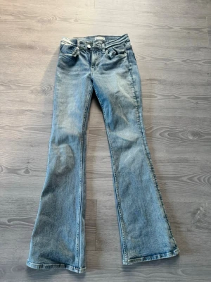 Ljusblå bootcut jeans från Perfect Jeans - Säljer ett par ljusblå bootcut jeans från Perfect Jeans i storlek 34. Jeansen har klassisk femficksdesign, normal midja och utsvängda ben. Tillverkade i mjukt denimtyg som ger en avslappnad och trendig look.