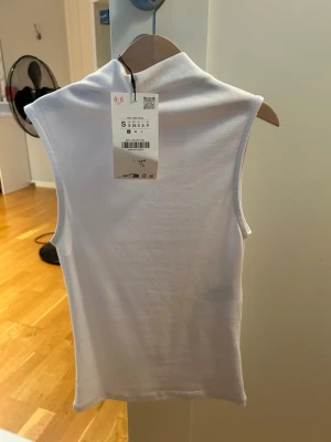 Vit top - Säljer min vita top från Zara då den inte används längre. Har en i storlek S och en i M men passar på de som har Xs och S med då de är mycket tighta. 