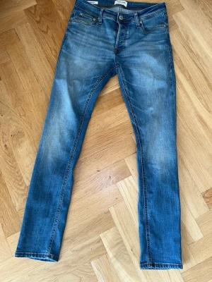 Slim Glenn jeans från Jack & Jones strl 29/30 - Snygga blå Slim Glenn jeans från Jack & Jones med smal passform och klassisk femficksdesign. Jeansen är i mycket fint skick. Pris kan diskuteras.