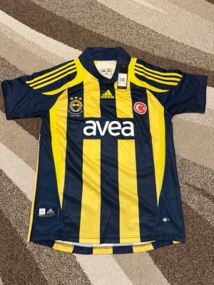 Fenerbahce 07-08 hemmatröja - Säljer Fenerbahce retro tröja från 07-08 säsongen. Den har Alex 10 där bak och är i Storlek M. Den är helt ny och perfekt för ett Fenerbahce fan.