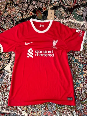 Liverpool matchtröja röd Nike - 🇩🇪 OBS! Jag reser till Tyskland 23 Juli – 30 Juli och kan därför inte skicka paket under denna period.  ✅ Plagget är i nyskick med originallapp och förpackning kvar.  📦 Köper du nu reserverar jag varan åt dig och skickar direkt när jag är tillbaka den 30 Juli. Betalning sker nu, frakt sker efter hemkomst.  💬 Hör av dig om du har frågor – svarar så snart jag kan! 🙏