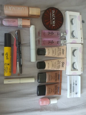 Basprodukter för smink och hud - Några helt nya saker och några som är använda men finns mycket kvar i!❤️ Ett kit med flera basprodukter för smink, inklusive foundation från Lumina, bronzing powder från Isadora, concealer, ögonfransserum, lösögonfransar, skin tint i olika nyanser, och rosa nagellack. Flera produkter i beige, rosa och bruna toner. Perfekt för en komplett basrutin.