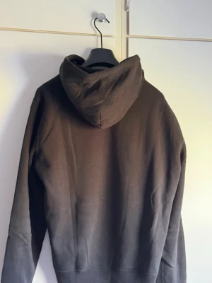 Svart hoodie Polo Bear Ralph Lauren - Säljer en svart hoodie från Ralph Lauren med Polo Bear-broderi på bröstet. Hoodien har huva med dragsko och en stor magficka framtill. Mjuk bomullskänsla och klassisk passform, perfekt för en avslappnad stil.