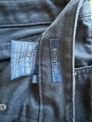 Svarta  jeans från Batistini - Snygga svarta  jeans från Batistini med klassisk femficksmodell. Tillverkade i en mjuk blandning av bomull och polyester för extra komfort. Passar perfekt till en avslappnad stil och har raka ben. Material: 65% bomull, 35% polyester.