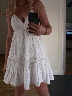 Vit blommig kort sommarklänning - Säljer denna söta sommar klänning! Klänningen är ifrån H&M i storlek XS. Men skulle säga att den är ganska stor i storleken så mera S/M. Säljer pga att den inte kom till användning ❤️ skriv privat för mera bilder ❤️